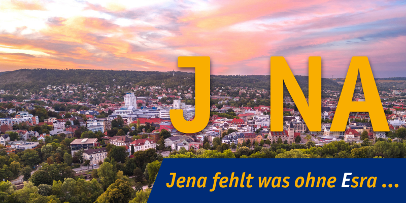 Blick auf die Stadtsliluette von Jena mit wolkigem farbigen Himmel. Schrift auf dem Bild: JNA - Jena fehlt was ohne Esra...