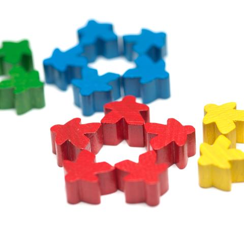Spielfiguren verschiedener Farben vor einem weißen Hintergrund