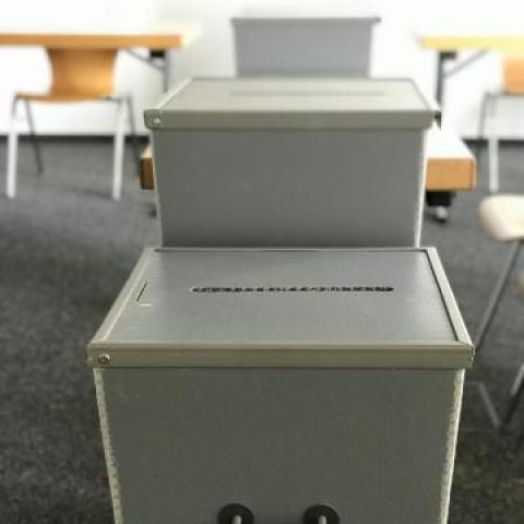 Wahlurnen im Wahllokal: große graue Kästen zum Einwerfen des Wahlzettels