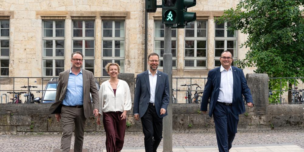 Vier Personen an einem Fußgängerüberweg 