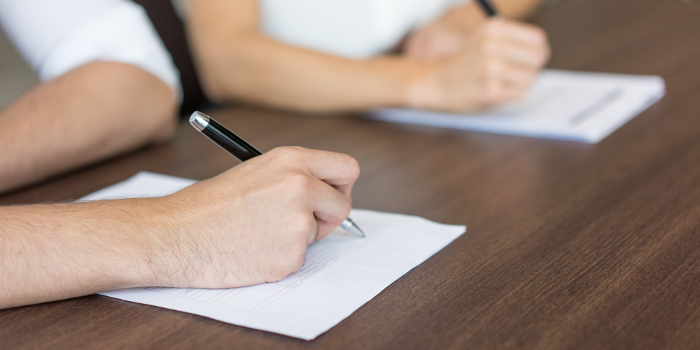 Zwei Hände, die Notizen auf Zetteln machen