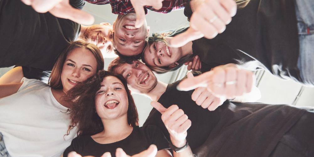 Junge Menschen stehen im Kreis und haben Spaß