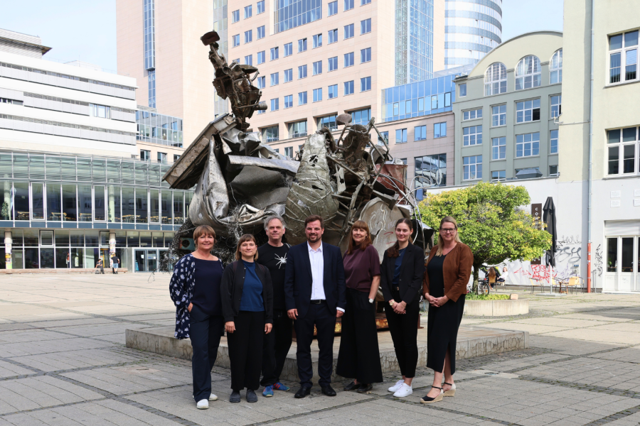 Gruppe von Menschen stehen vor einer Skulptur auf dem Ernst-Abbe-PLatz in Jena.