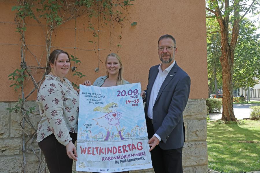 Drei Personen mit Plakat