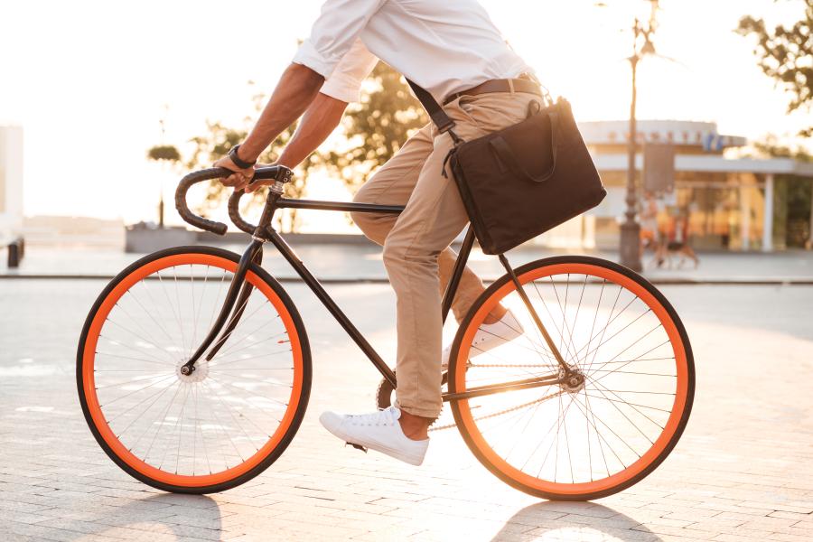 Ein Mann fährt durch eine Stadt mit einem Rad.