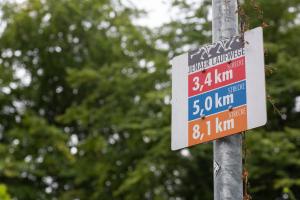 Schild an einem Laternenmast was in drei verschiedenen Farben die unterschiedlichen Laufstrecken zeigt.