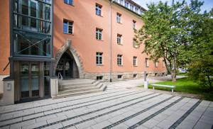 Blick auf ein orangefarbenes Gebäude mit Treppe davor