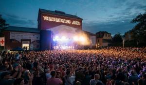 Konzertmoment der Kulturarena Jena mit Blick auf die abendlich erleuchtete Bühne und das Publikum