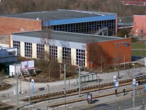 Blick auf mehrere Gebäude mit Starßen und Straßenbahnen von oben