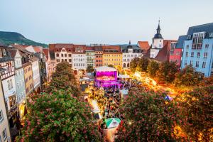 Vogelperspektive bei Dämmerung auf den Historischen Marktplatz Jena während des Jenaer Frühlingsmarkt mit Bühne, Ständen und einer Menschenmenge