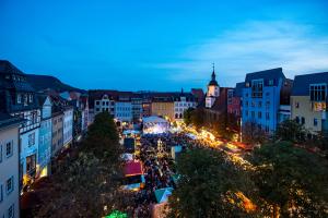 Blick auf das Jenaer Altstadtfest auf dem historischen Marktplatz zu abendlicher Stunde mit vielen Ständen und beleuchteter Bühne